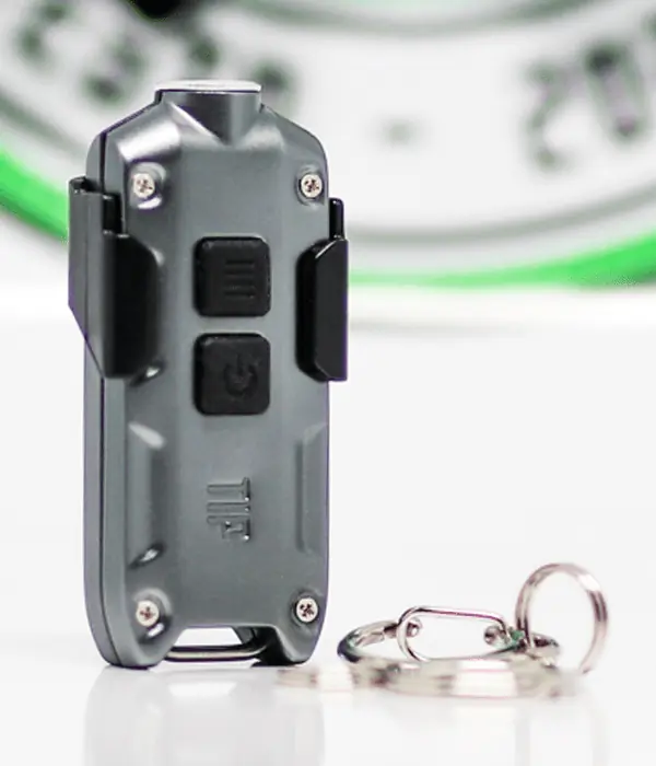 Front view of grey Nitecore TIP LED keyring torch with dual buttons, TIP branding, pocket clip and keyring accessories