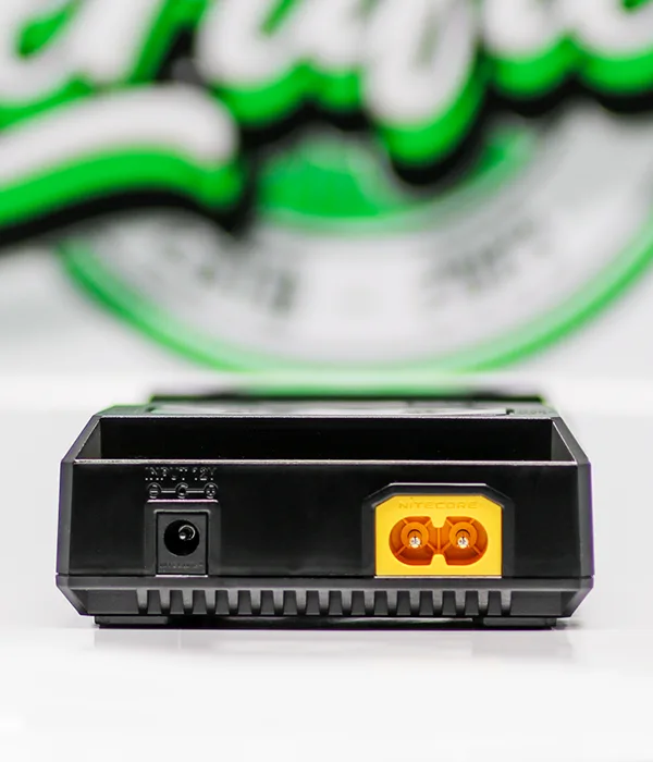 Rear of the Nitecore NEW i4 charger showing a round DC input socket and a yellow two-pin mains inlet above a row of vents