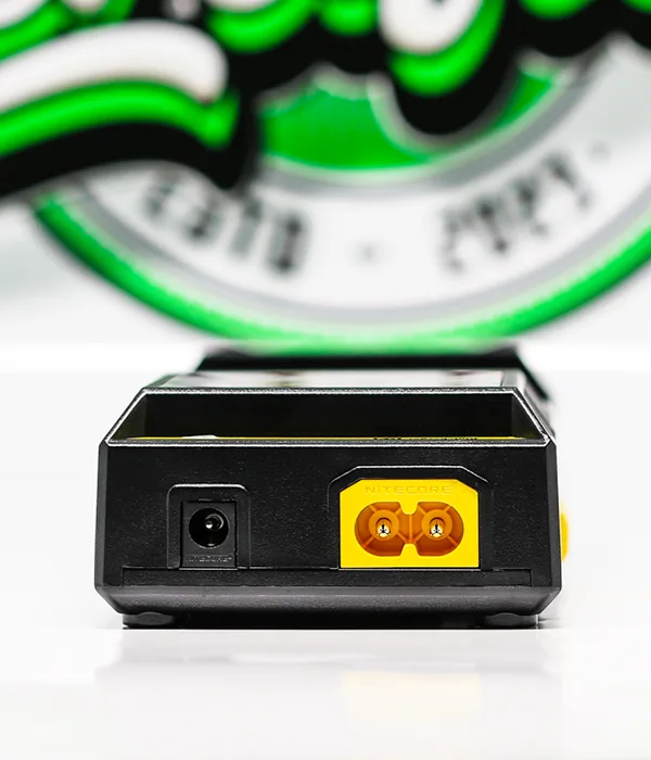 Rear panel of the Nitecore D2 charger with a round DC input jack beside a yellow two-pin mains power inlet